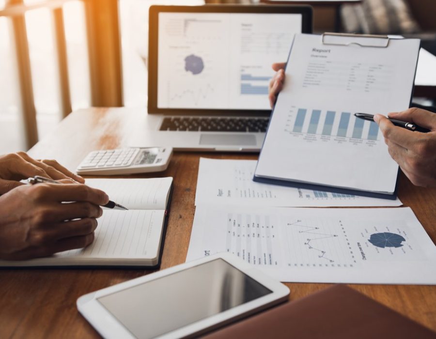 Two business partnership coworkers analysis strategy with discussing a financial planning graph and company budget during a budget meeting in office room.