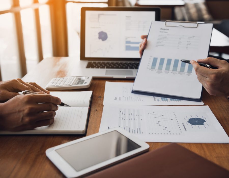 Two business partnership coworkers analysis strategy with discussing a financial planning graph and company budget during a budget meeting in office room.